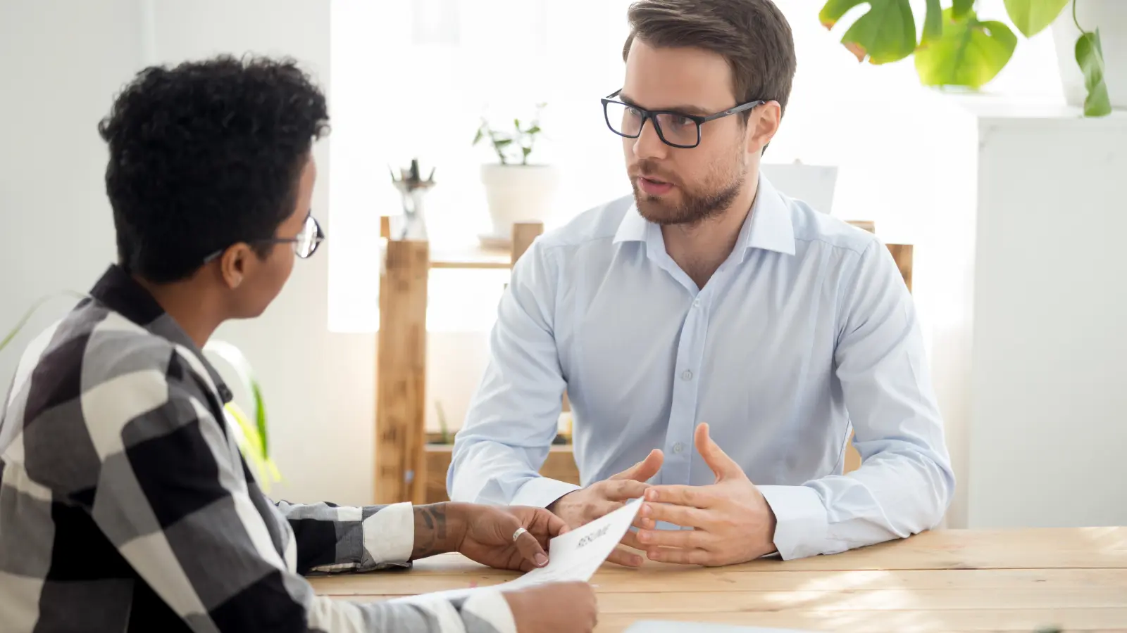 A photo of a hiring manager interviewing a job candidate.