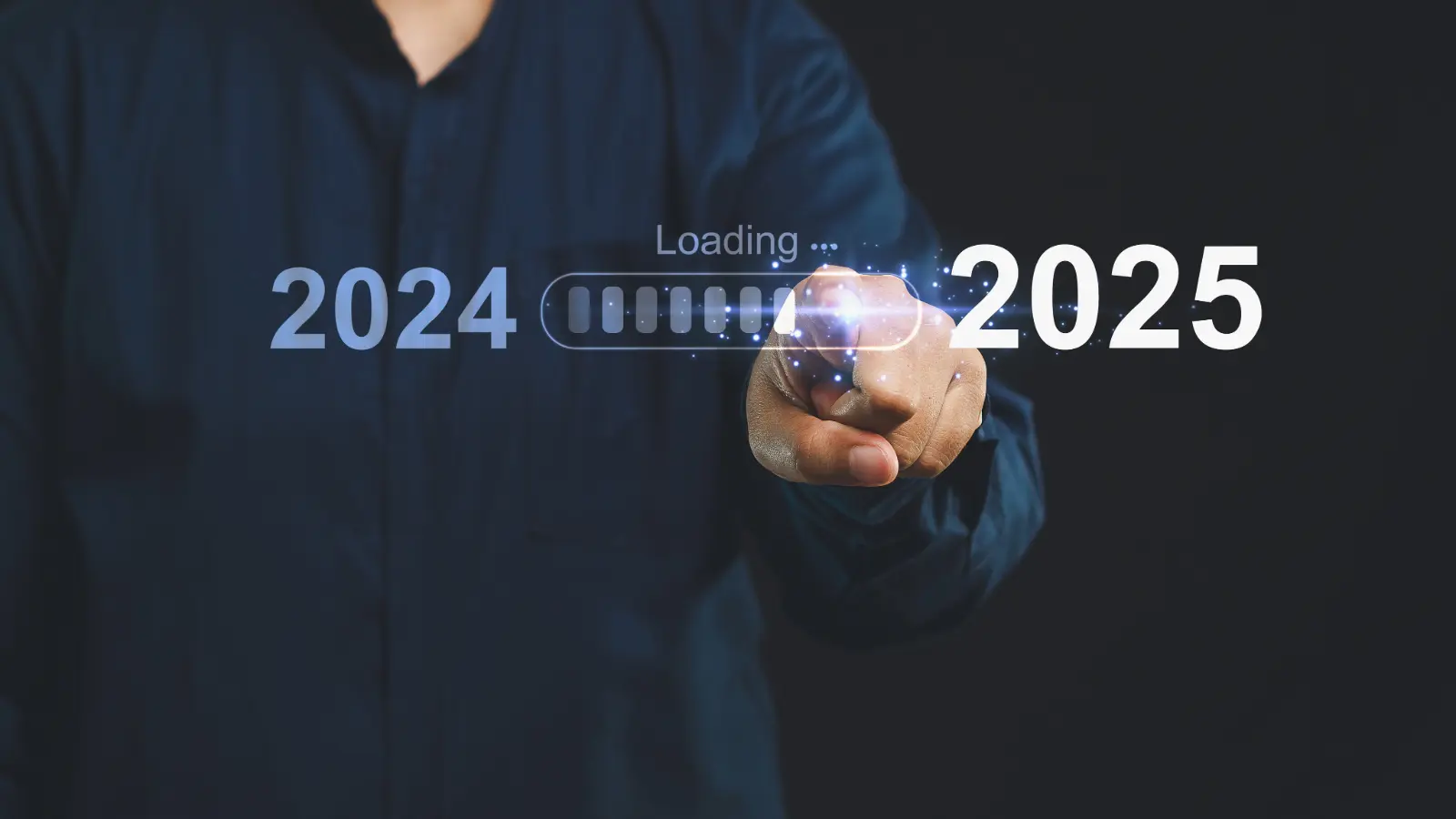 A hand touches a glass screen with a loading symbol representing the transition from 2024 to 2025.